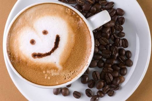 Cup of coffee on plate with smiley face
