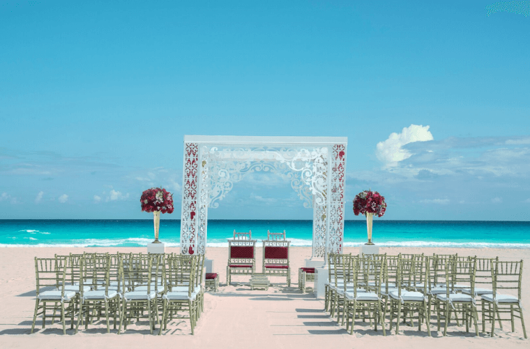beach wedding setup at Iberostar Selection Cancu n with a wedding arch and chairs set for the bride and groom and guests 