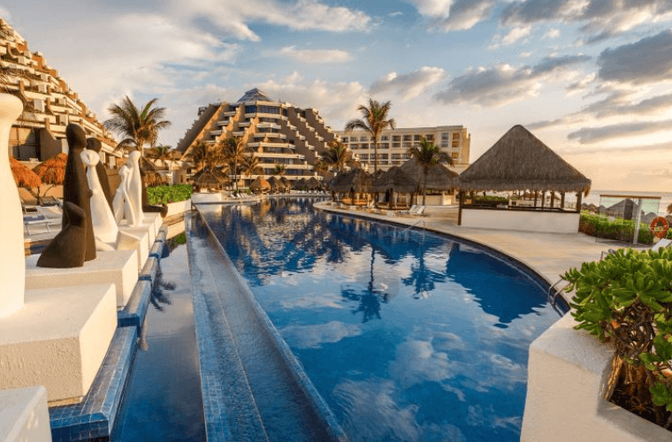 the pool at Paradisus Cancun with the accommodation in a pyramid shape in the background 