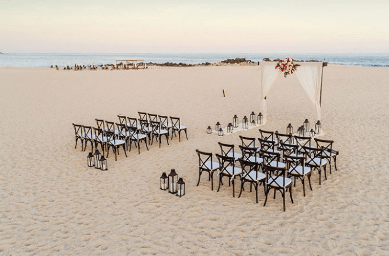 the beach wedding setup at Paradisus Cancun with rows of chairs facing a wedding arch