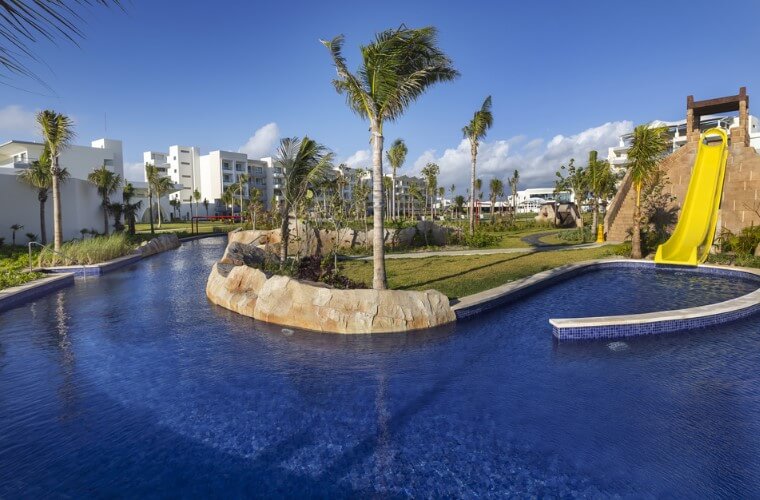 the lazy river at Planet Hollywood Cancun with a slide and palm tress 