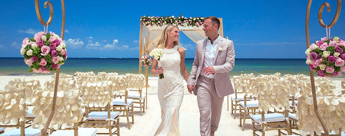 Happy couple walking down the aisle at the Royalton Resorts