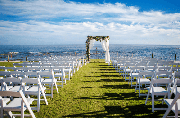 wedding set up at Grand Fiesta Americana Los Cabos with a wedding arch, white chairs, and views of the Caribbean Sea