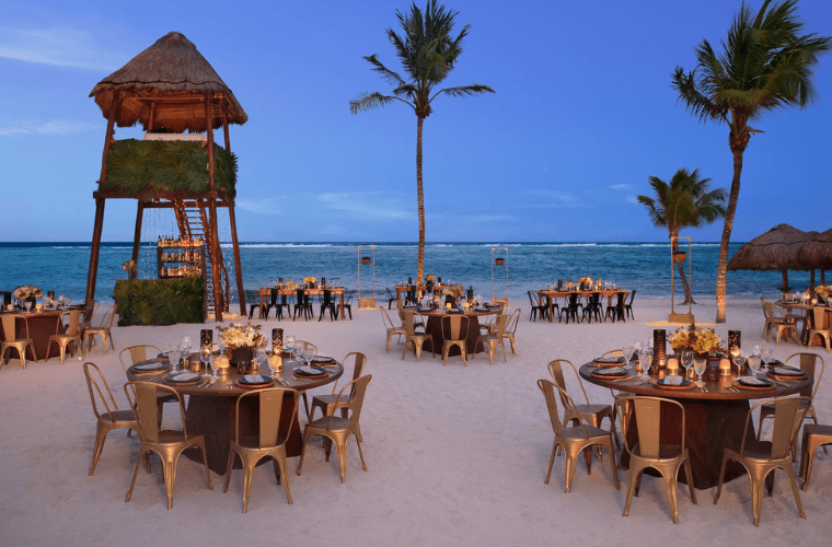beach buffet setup at Secrets Akumal set with round tables and with views of the Caribbean Sea