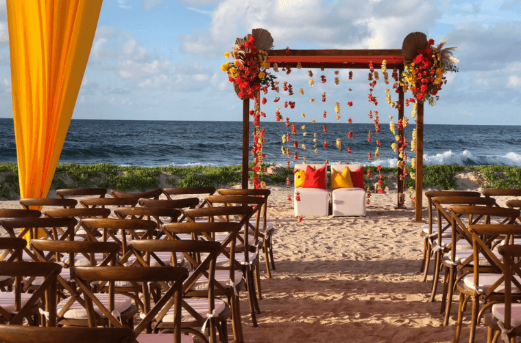 beach wedding set up with a wooden arch and chairs 