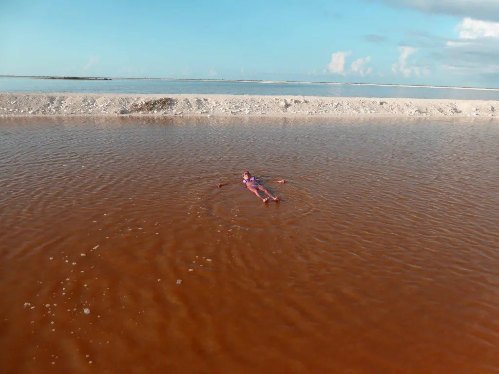 Girl floating in salt water in Rio Lagartos