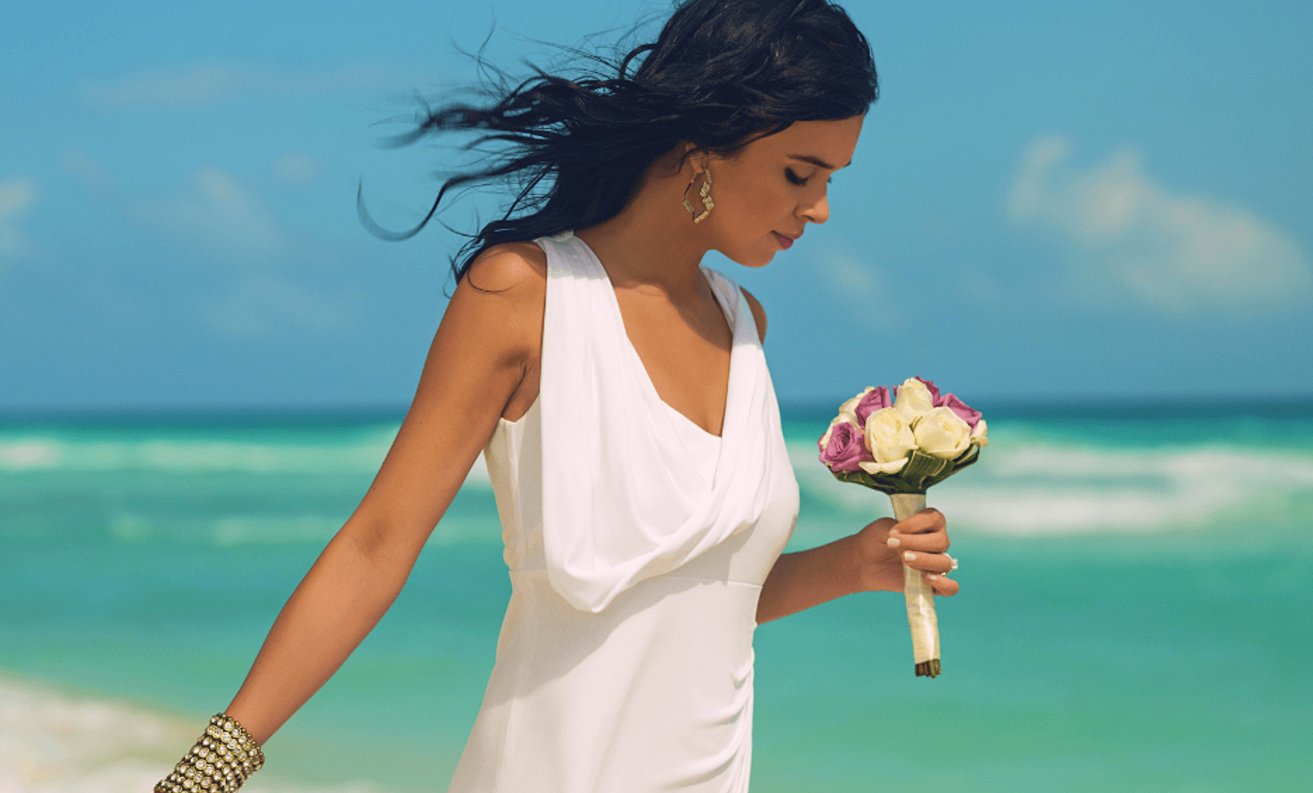 Girl holding a bouquet of flowers on beach in Playa del Carmen