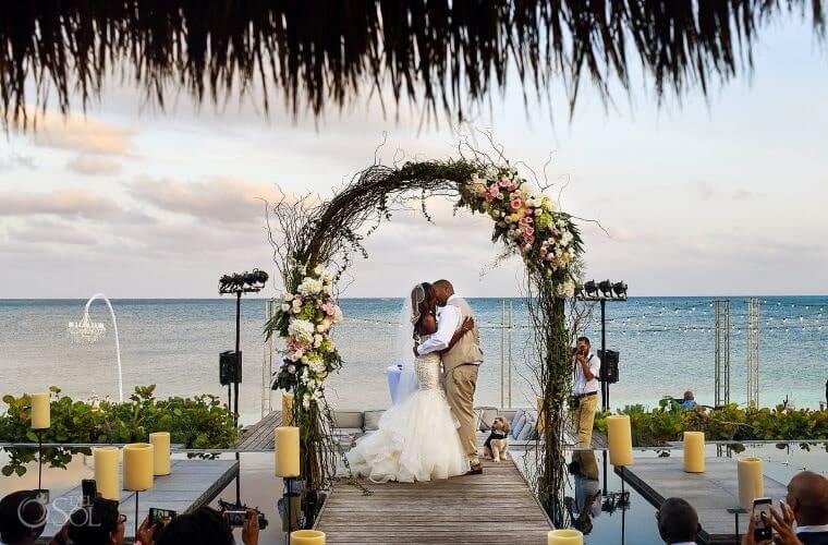 wedding couple under an arch at Nizuc Resort and Spa 
