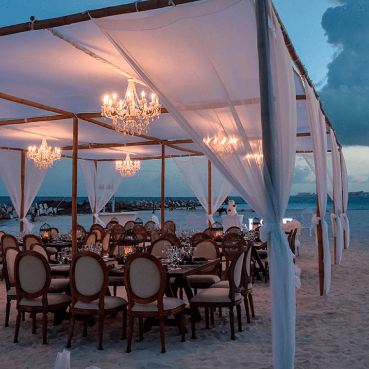 tables on the beach at dusk set for a wedding at Hyatt Ziva 