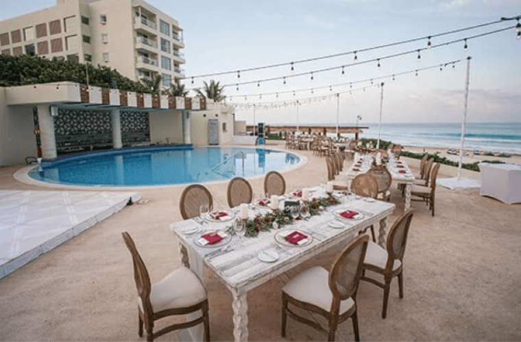 table set for a wedding reception by the pool at Live Aqua Cancun 