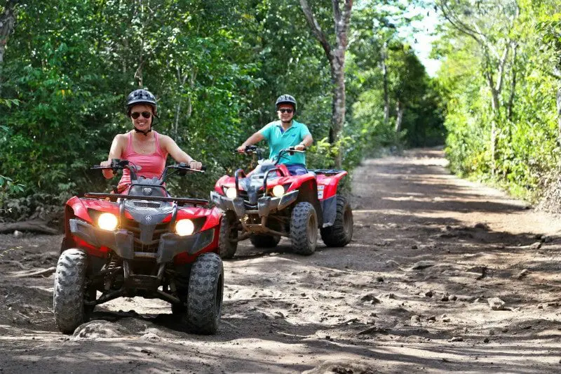 Two people ride ATVs through the Riviera Maya jungle outside of Playa del Carmen