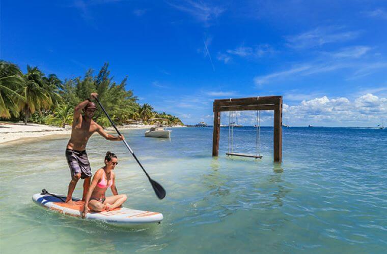 a couple on a paddleboard at Zama Beach Club 