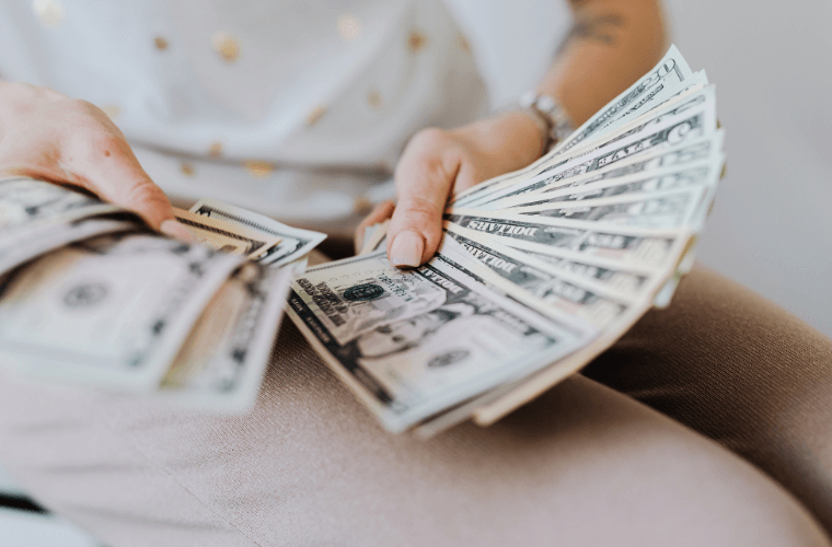 hands holding dollar notes of different denominations 