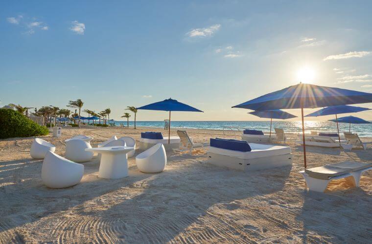 Beach with seating area and umbrellas at Live Aqua Cancun