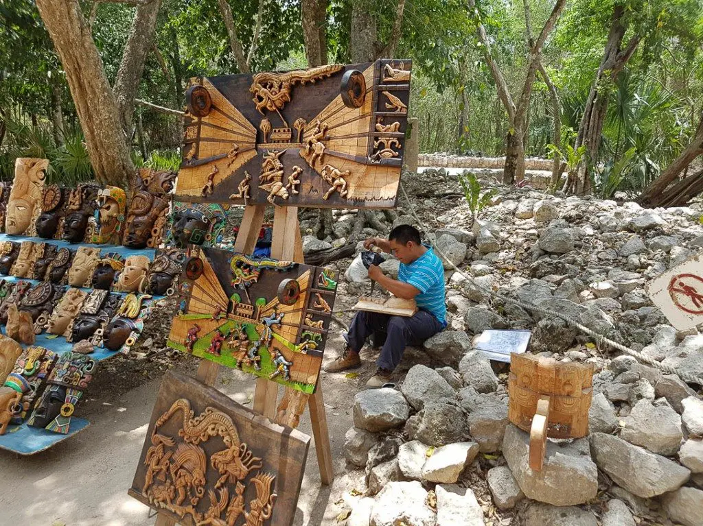 Local artist and resident Efrain Cetz carves wood at Chichen Itza