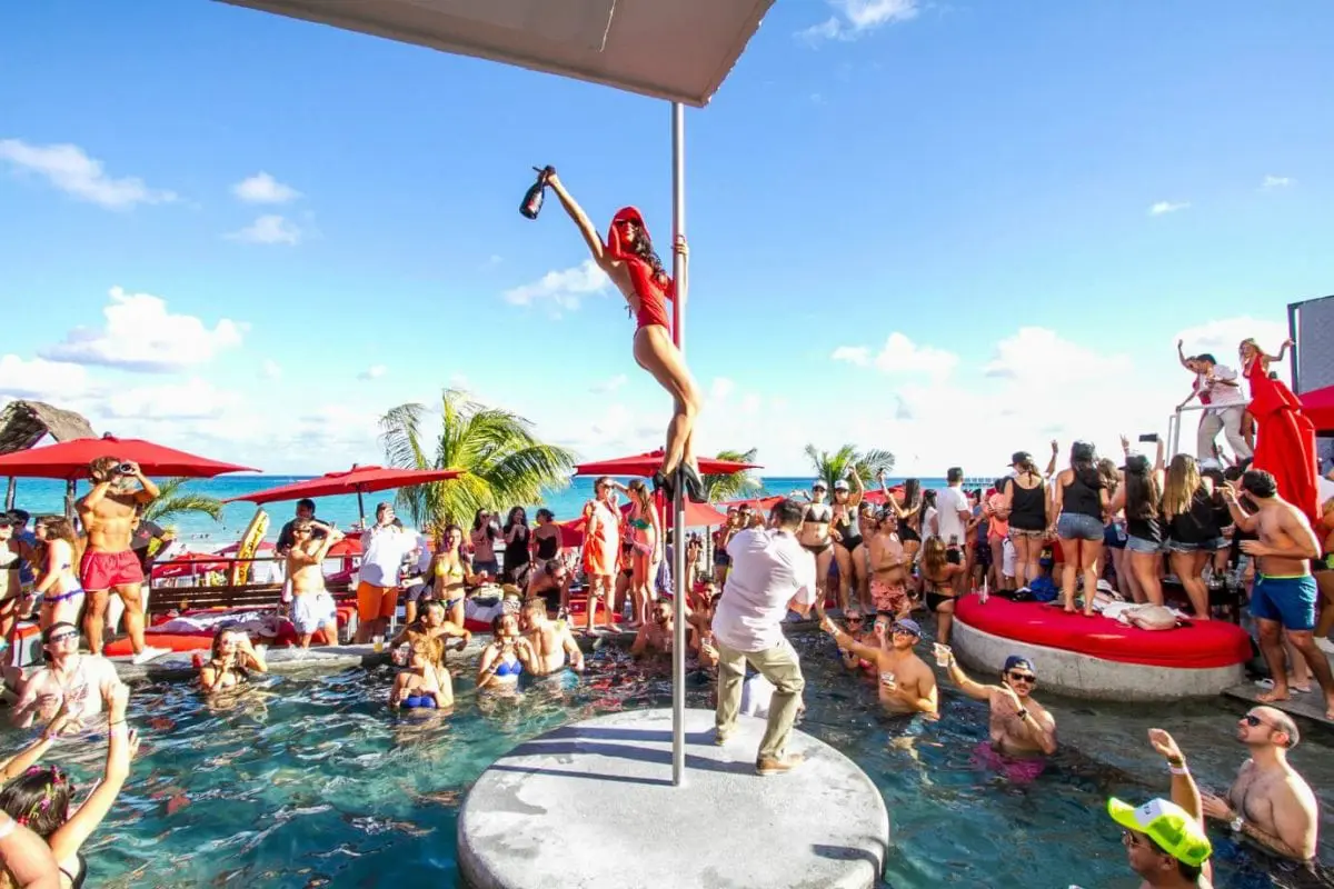 Girl climbing a pole at Coralina beach club part