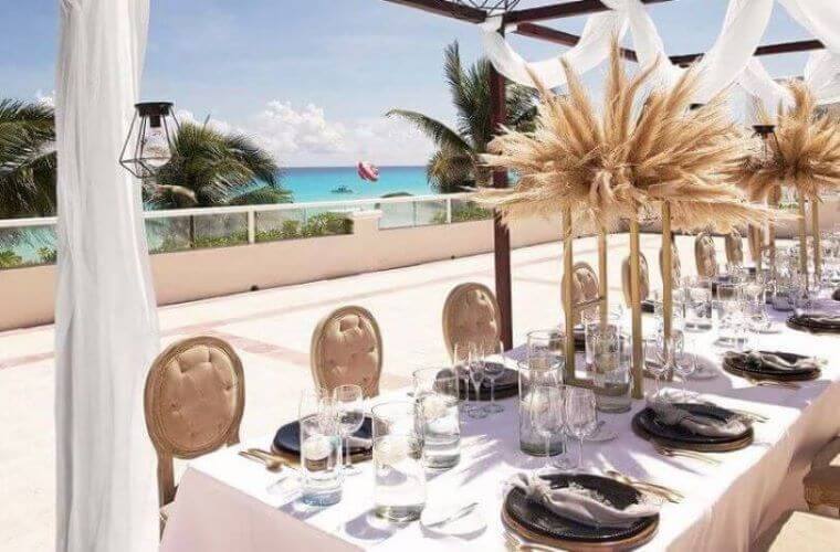 a table set for a wedding celebration with the Caribbean Sea in the background 
