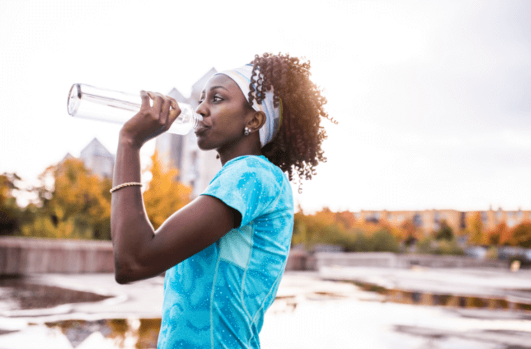 a girl drinking water from a bottle 