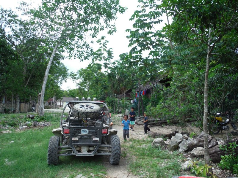 kids playing beside a dune buggy 