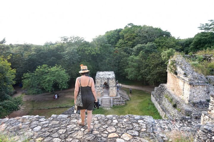 A tourist looks out at the Ek Balam Mayan ruins from atop a pyramid