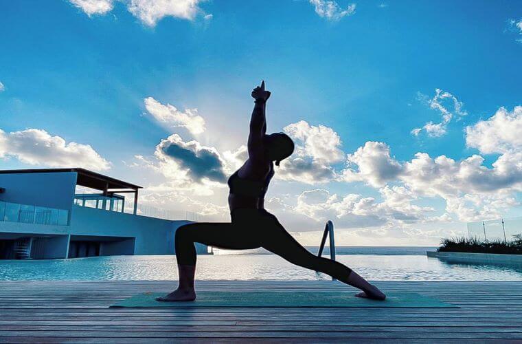 a person striking a yoga pose with Caribbean skies as a backdrop