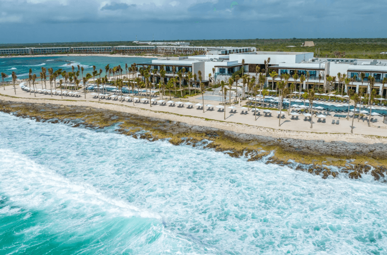 beach at Hilton Tulum with the resort behind it