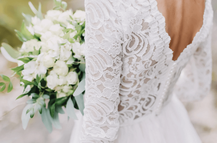 the back of a bride wearing a lacy white wedding dress