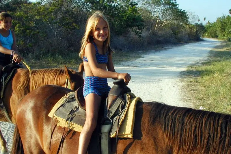 Girl riding a horse on a jungle trail near Playa del Carmen Mexico