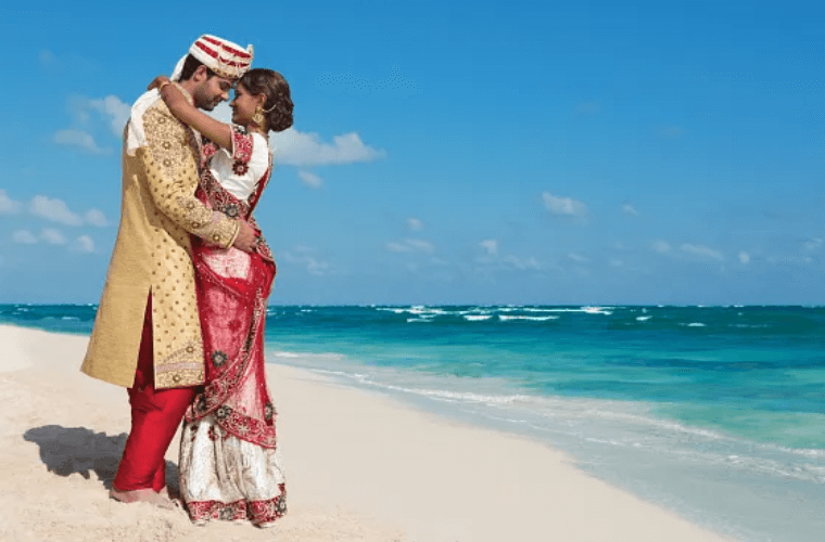 Indian couple in traditional dress on a beach 