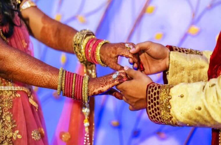 the hands of a wedding couple holding each other during a ceremony