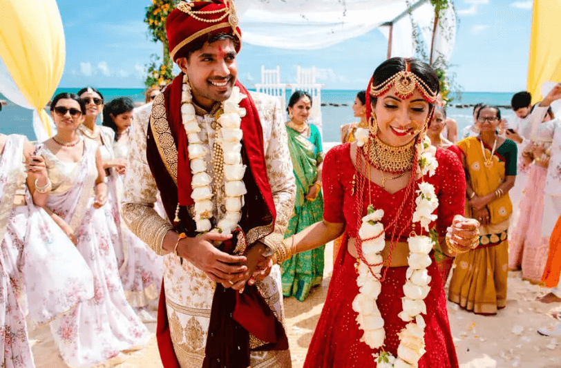 an Indian couple on a beach on their wedding day