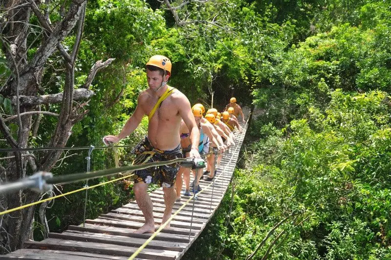 Tourists crossing a jungle bridge on the Mayan Xtreme tour with PlayaDelCarmen.com