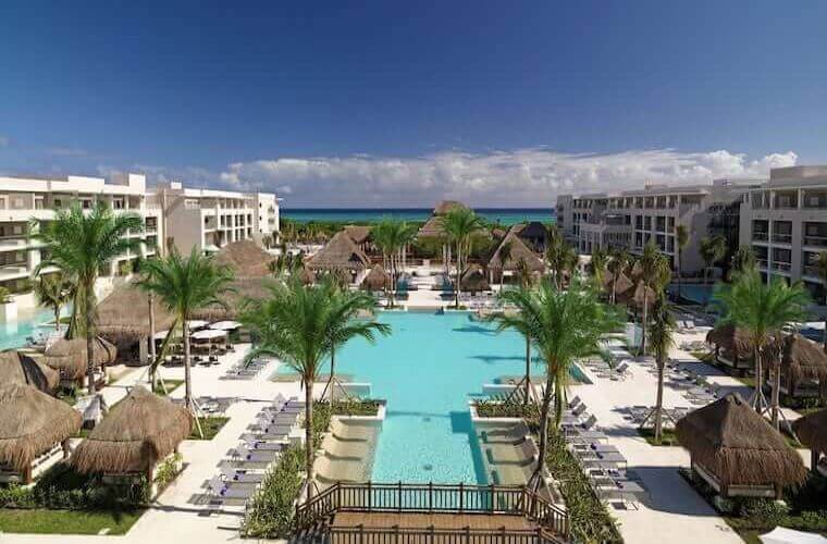 pool surrounded by palm trees and accommodation blocks at Paradisus Playa Del Carmen