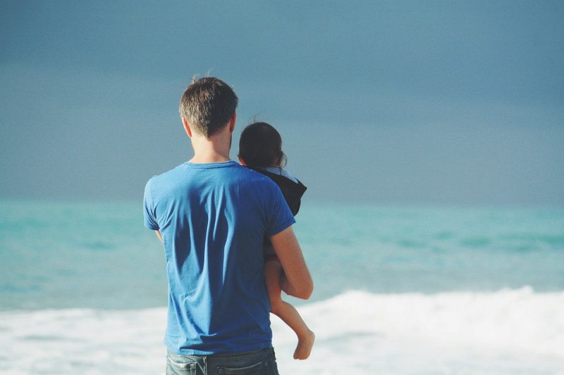 Man holds child at Playa del Carmen beach