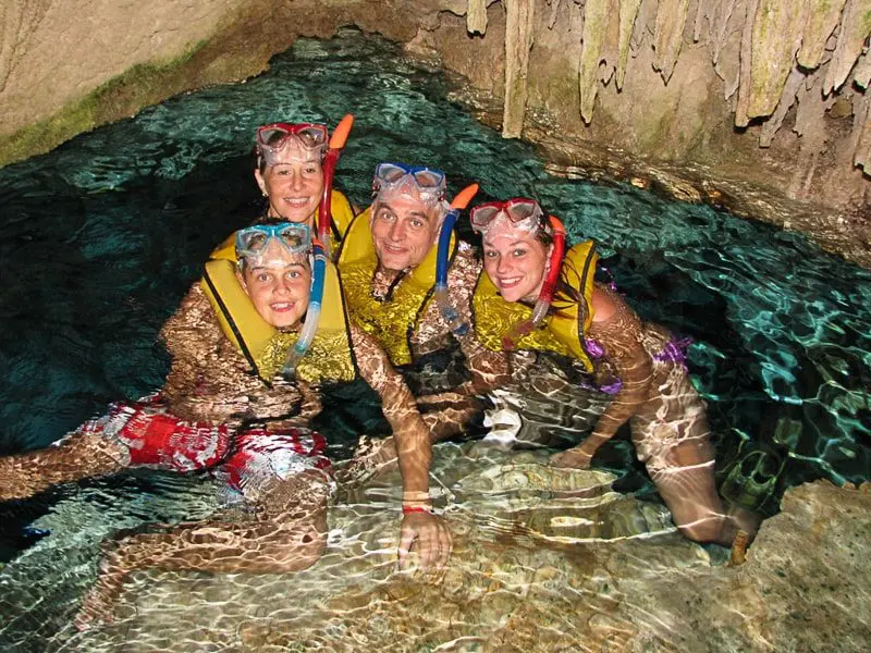 A family poses for the camera while snorkeling in a cave outside of Playa del Carmen, Mexico