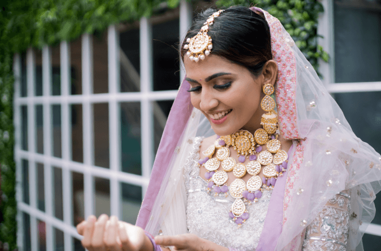 an Indian bride wearing a pink wedding outfit 