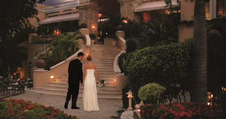 wedding couple at the foot of a staircase in the grounds of Royal Hideaway Playacar