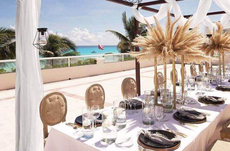table set for a wedding at Wyndham Alltra with the Caribbean Sea in the background 