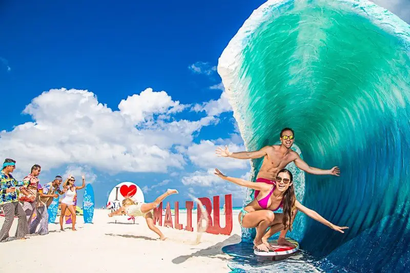 Couple posing under artificial wave at Sandos Playacar