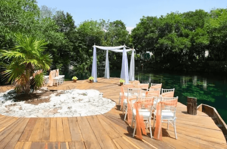 A wedding set up on a deck by water 