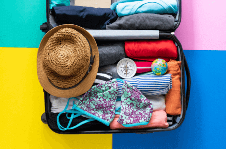 a travel bag containing accessories including a bikini and a hat