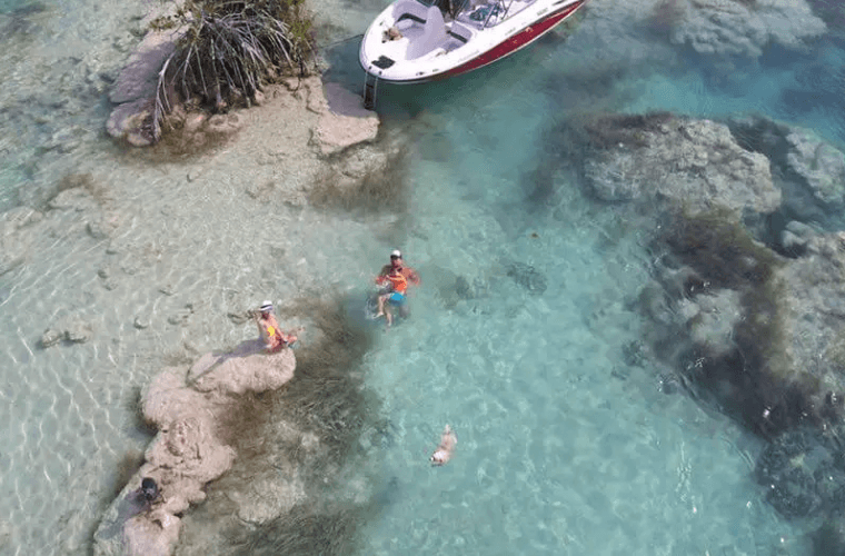 people swimming from a boat in the clear water at Bacalar