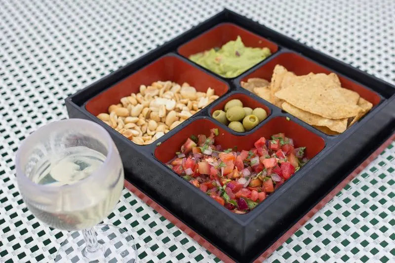 Sunset sailing tour snacks such as chips, olives, pico de gallo, guacamole, and peanuts