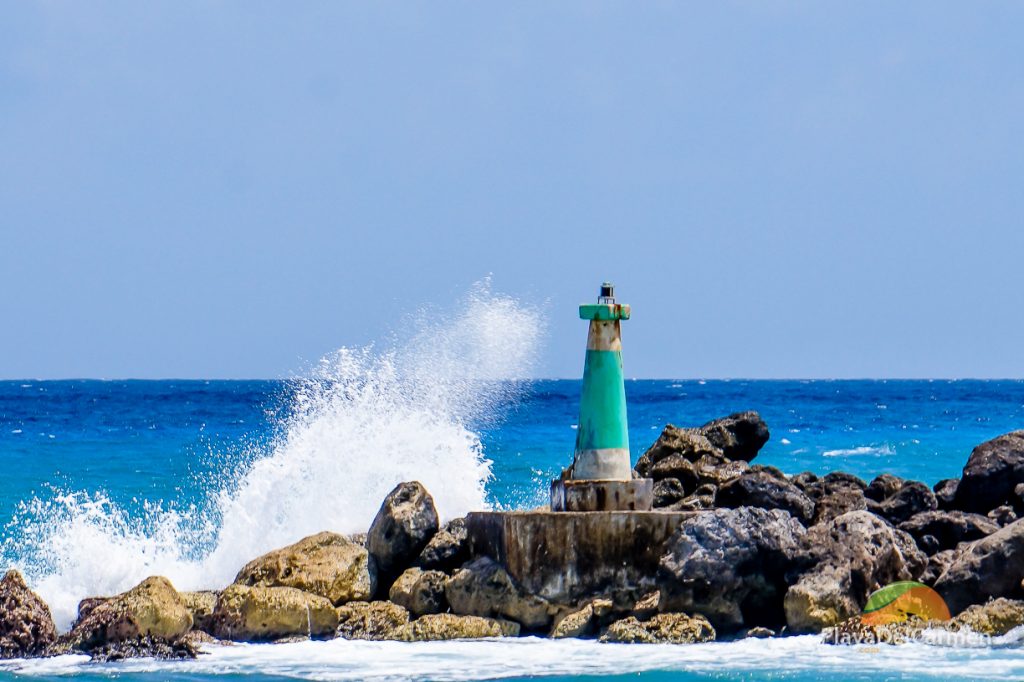 Waves crashing against the min-light tower in Puerto Aventuras