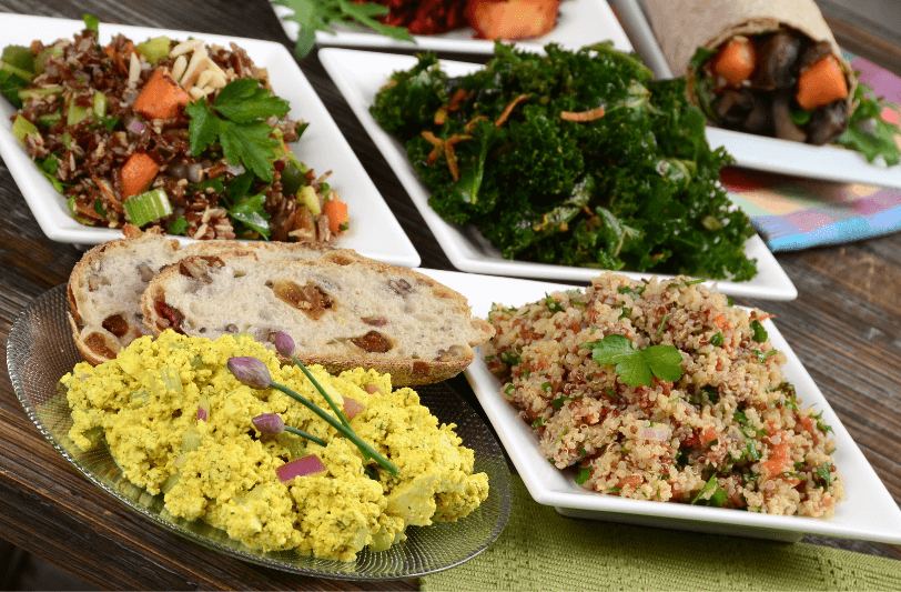 a selection of vegan dishes on plates on a wooden table