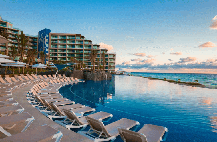 the pool area at Hard Rock Cancun with accommodation and the Caribbean Sea in the background 