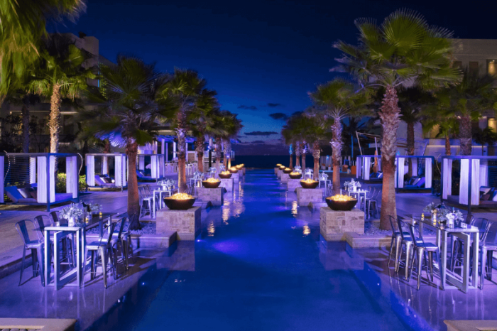 wedding cocktails setup at Breathless Riviera Cancun in the evening with palm trees and real flames