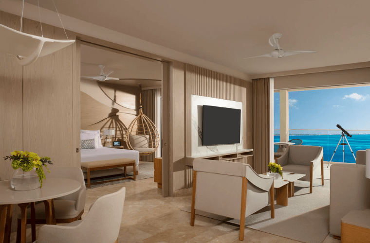 master suite with chairs and TV in living area and views of the Caribbean Sea 