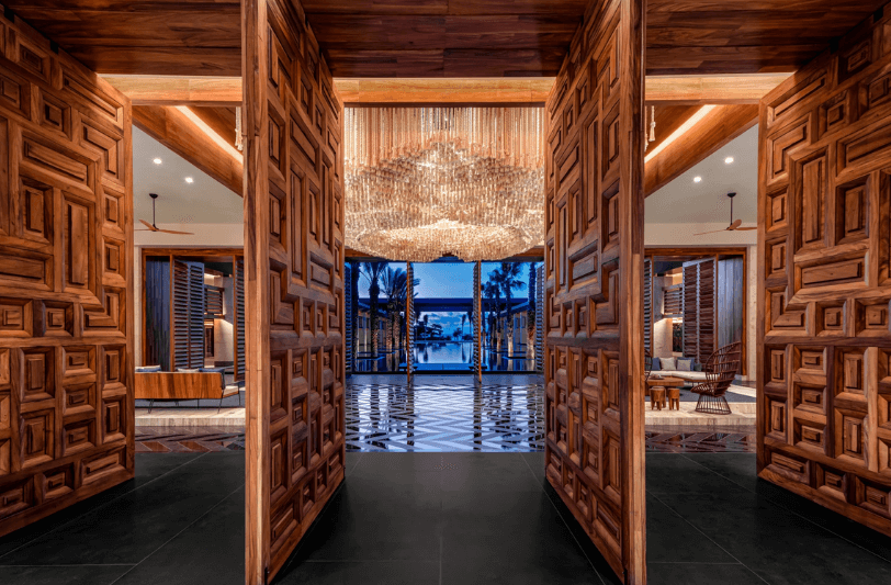 the lobby at Conrad Tulum Riviera Maya seen through wooden paneled doors
