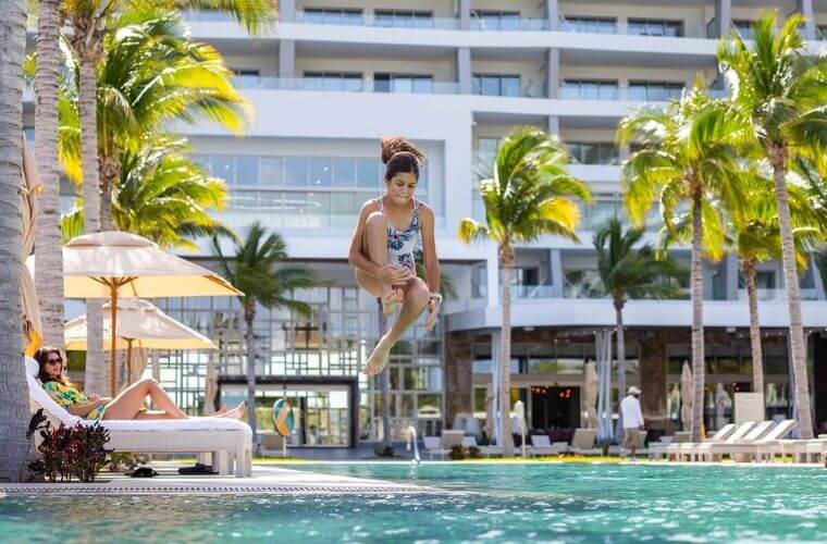 a girl jumping into a swimming pool